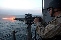A U.S. Navy 7,62 mm GAU-17/A Minigun. Ha un motore elettrico sulla parte superiore che effettua il carico, l'adescamento e lo sparo. Si noti l'espulsione rapida del bossolo