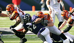 Baltimoras "Ravens" līnijsargs Rejs Lūiss cīnās ar Sinsinati "Bengals" skrienošo aizsargu Džeremiju Džonsonu Nacionālās futbola līgas spēlē.