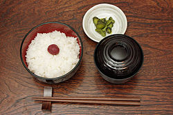 日本の典型的な食事：食器の手前側にある箸置きに箸を置き、左側を指す