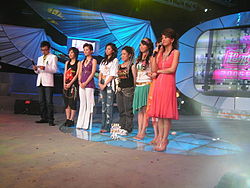 Sei finalisti durante un evento nazionale del 2005 a Changsha, Hunan. Da sinistra a destra: il conduttore Li Xiang, i concorrenti Lin Shuang, She Man Ni, Yi Hui, Jane Zhang (Zhang Liang Ying), Guo Hui Min, Li Na e il conduttore Wang Han.