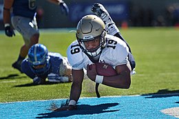 Hra amerického fotbalu (gridiron). Kanadský fotbal je velmi podobný.