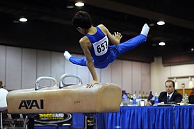 Una gimnasta en el caballo con arcos en una competición.