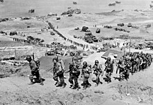 Acumularea de la Omaha Beach: întăriri de oameni și echipament care se deplasează spre interior 7 iunie 1944  