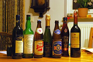 Kai kurie alkoholiniai gėrimai. Iš kairės į dešinę: raudonasis vynas, salyklinis viskis, lageris, putojantis vynas, lageris, vyšnių likeris ir raudonasis vynas.