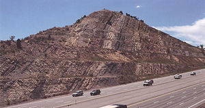 Coupure de route à l'endroit où la I-70 traverse Dinosaur Ridge à la sortie de l'autoroute 26. Les strates sont presque verticales, de sorte que la formation Morrison (à droite) sous-tend la formation Dakota (à gauche).