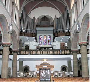 Este órgão em Luxemburgo tem seus tubos em três seções. O console do órgão pode ser visto ao lado direito da galeria abaixo do órgão. Há grandes tubulações de ar subindo para dentro do órgão por baixo da galeria.