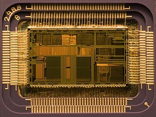 Microprocessor Intel i486DX2 (1992) : The opened case of the IC shows the 76 mm² semiconductor plate with 1.2 million transistors. The central rectangular area is the actual electronic circuit, with the leads for wiring to the pins of the package arranged on its sides. Functional units such as the processor's arithmetic unit and cache can be identified by different brightness levels.