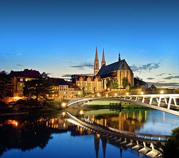 The pedestrian bridge from Görlitz to Zgorzelec, opened in 2004; in the background the Protestant parish church of St. Peter and Paul and the Waidhaus