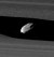 Two bright bands run from the left to right. In the narrow gap between them (Keeler gap), which has wavy edges, a small oblong object can be seen.