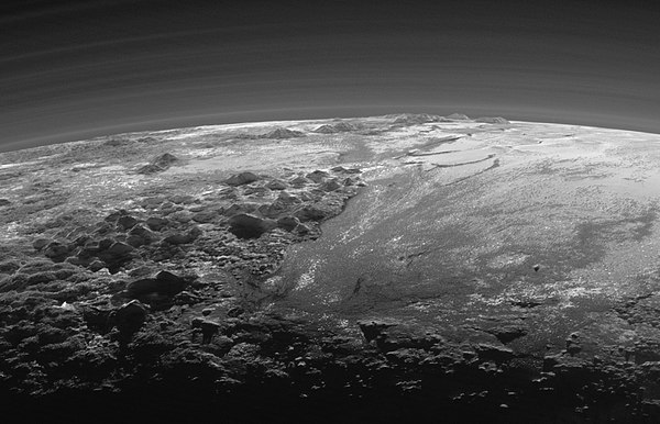 Plutone - Norgay Montes (a sinistra); Hillary Montes (a sinistra); Sputnik Planitia (a destra) La vista quasi al tramonto comprende diversi strati di nebbia atmosferica.