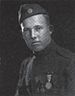 Head and shoulders of a young man in a military uniform with an array of medals on his chest and a garrison cap with a "US" button.