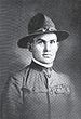 Head and shoulders of a clean-cut square-jawed young man in an army uniform, U.S. Army World War I style, with a campaign hat.