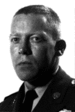 A black and white image of Hooper wearing his army dress uniform with tie and no hat. He is turned slightly to the left.