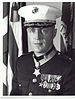A black and white image of Lee from the waist up in his military dress blue uniform with medals and hat. His Medal of Honor can be seen around his neck.