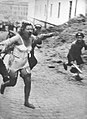 A Jewish woman is chased by men with clubs in a pogrom in Ukraine