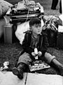 A young boy waits to be taken to an internment camp