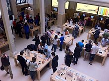 Visitors to an Apple Store in Paris try out products.