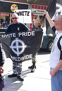 Banderoll som hålls upp av en person vid ett "White Pride"-möte i Calgary, Kanada.  