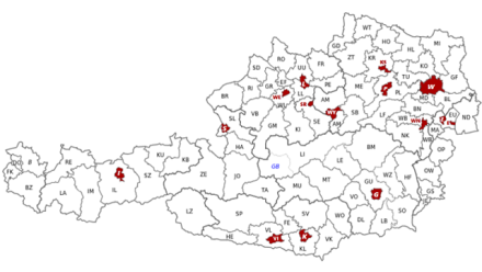 94 současných okresů Rakouska. Červeně jsou vyznačena statutární města.