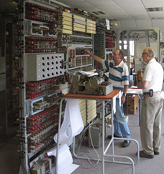 In 2006 heeft Tony Sale (rechts) de leiding. Zij breken een vercijferd bericht met de voltooide machine. Sinds 1994 bouwt zijn team een nieuwe Colossus computer in Bletchley Park.