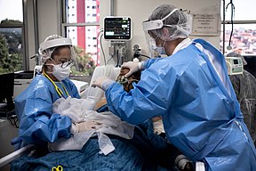 A nurse caring for a patient with COVID‑19 in an intensive care unit