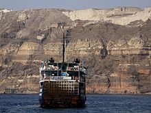 The caldera wall shows the stratification of the volcanic rock