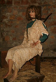 En mannequin placeres i en garrot for at demonstrere, hvordan et menneske sidder i anordningen  