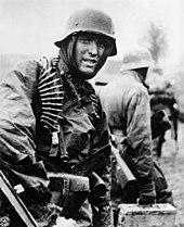 Een Duitse mitrailleurschutter marcheert door de Ardennen in december 1944.  