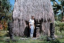 Tiki-statyer framför ett traditionellt hawaiianskt hale (hus). Turistattraktion, 1959