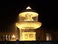 The fountains of Maderna and Bernini are lit up at night.