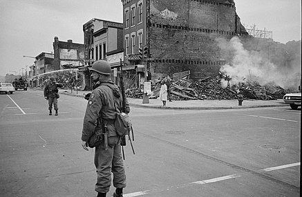 Soliders stand near buildings ruined by riots in Washington, D.C.
