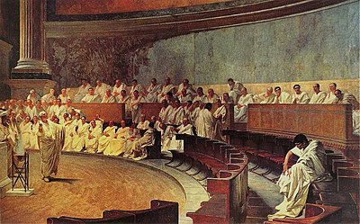 El senado romano: Cicerón ataca a Catilina, de un fresco del siglo XIX en el Palacio Madama de Roma, casa del Senado italiano. Esta opinión es probablemente errónea. El edificio existente de la Curia Julia, que data del emperador Diocleciano, muestra que los senadores se sentaban en líneas rectas y paralelas a ambos lados, en el interior del edificio  