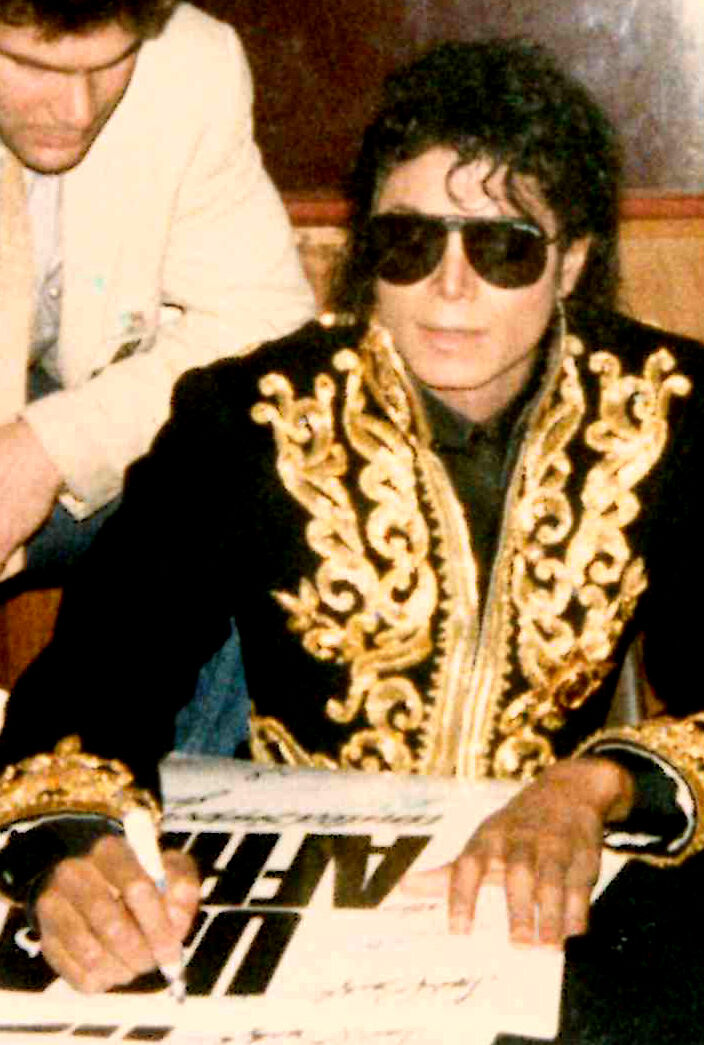 Michael Jackson signerer en plakat i 1985.  