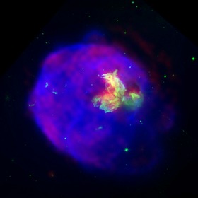 Supernovaremsan LMC N 63A avbildad i röntgenstrålning (blått), optisk strålning (grönt) och radiostrålning (rött). Röntgenljuset kommer från material som värms upp till cirka tio miljoner grader Celsius av en chockvåg som uppstod vid supernovaexplosionen.