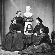 Le cinque figlie di Vittoria (Alice, Helena, Beatrice, Victoria e Louise), fotografate in nero da lutto sotto il busto del loro defunto padre, il principe Alberto (1862)
