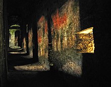 Projection of roofs and treetops opposite a wall with embrasures on a wall in Bellinzona