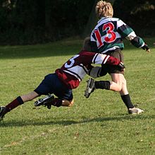 Rugbytaklaus: taklauksen on oltava vartalon alapuolella, ja sen tarkoituksena on estää palloa pitävää pelaajaa pääsemästä pallon kanssa maahan.