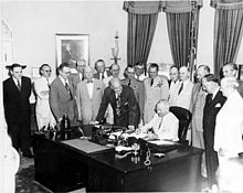 Il presidente Truman firma l'emendamento del National Security Act del 1949 con ospiti nello Studio Ovale.