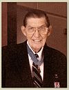 Color photo of Barfoot wearing his Medal of Honor and a blue suit. He is facing the camera and smiling.