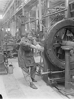 Robotníčka obsluhuje stroj na streľbu z námorných diel v Kráľovskej továrni na zbrane, 1918