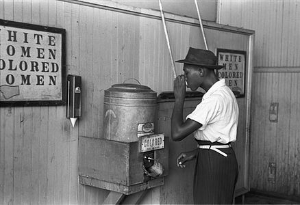 A black man drinks from a "colored" drinking fountain in Oklahoma City (1939)